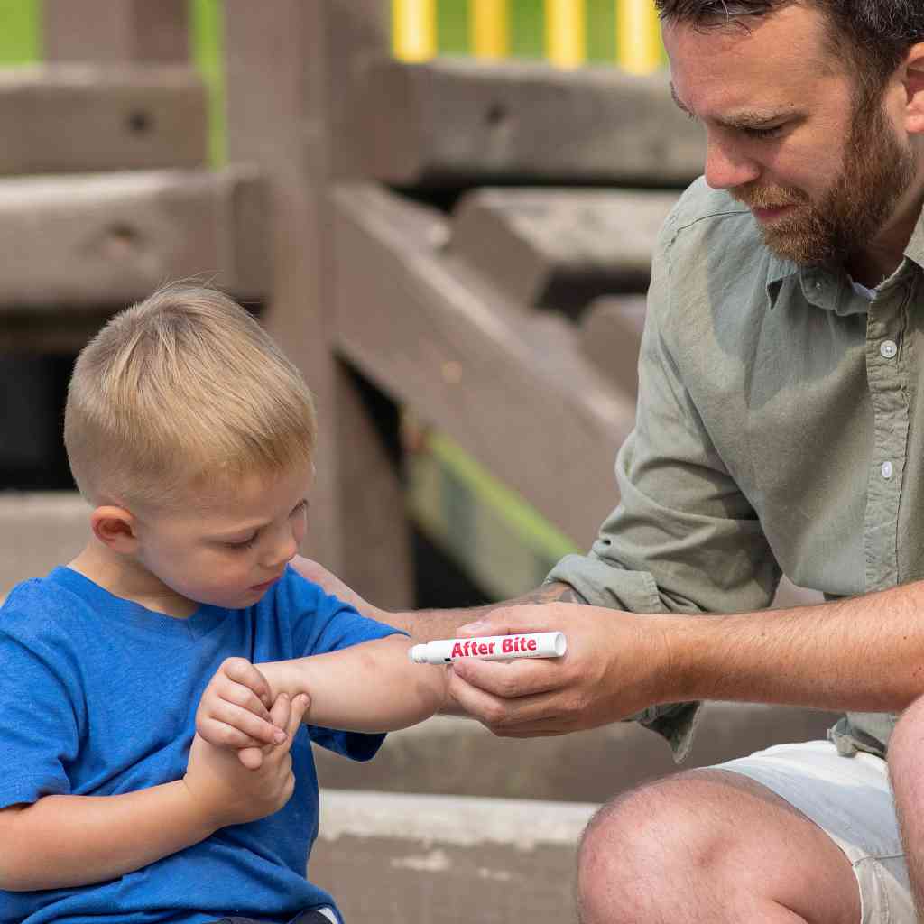 After Bite Advanced father applying to son's arm on a playground
