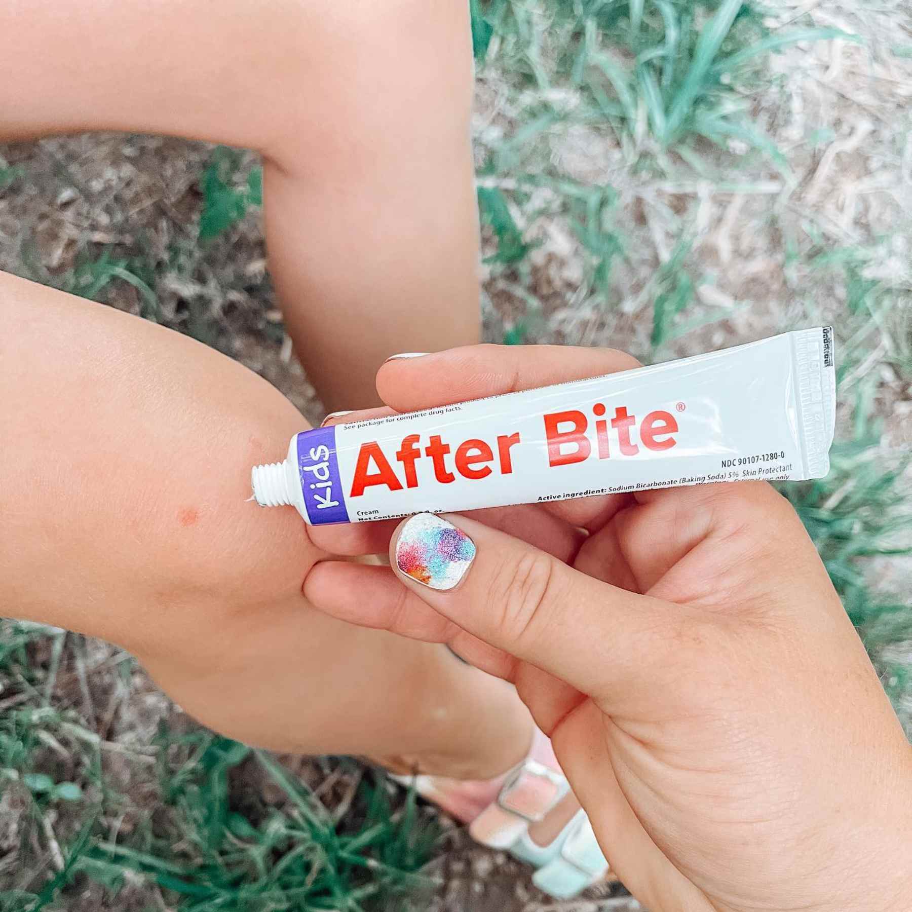Mom applying After Bite Kids to child's leg