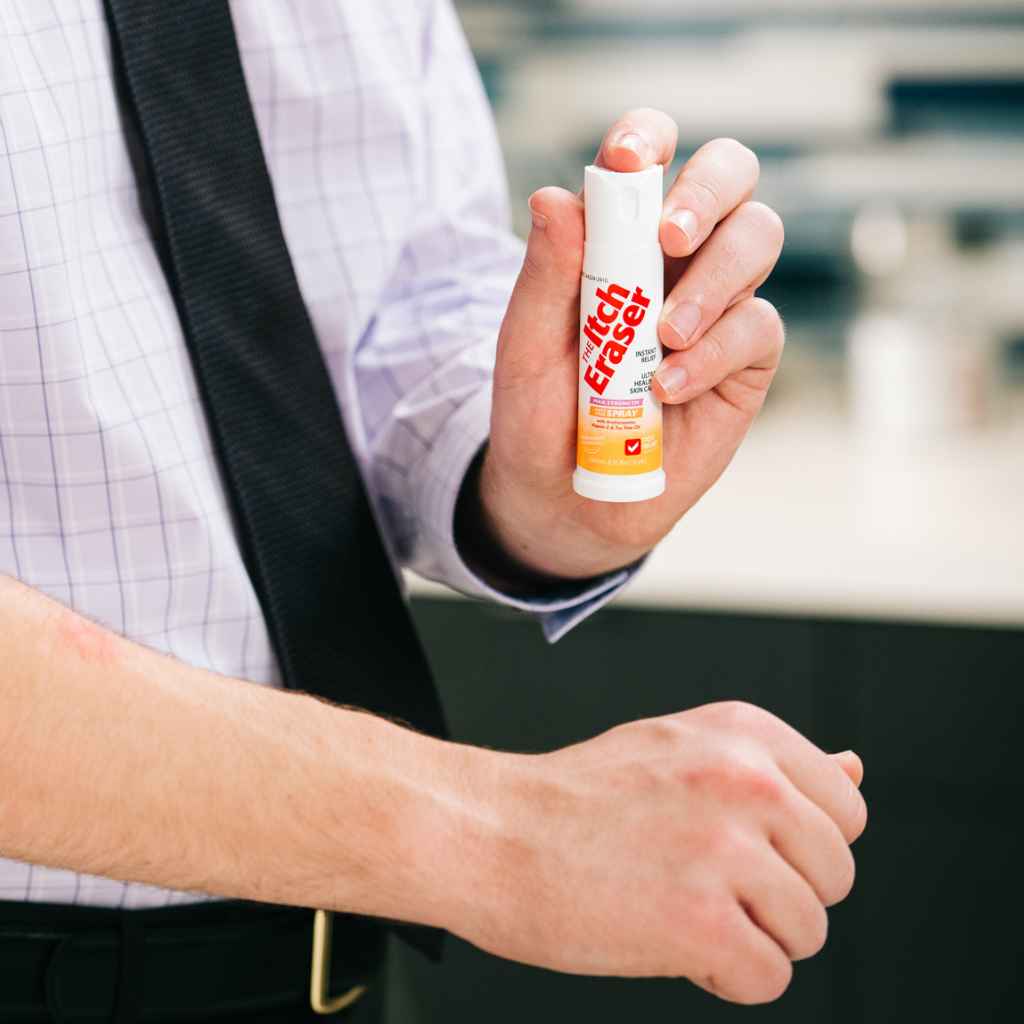 The Itch Eraser Spray man wearing a tie about to spray on arm