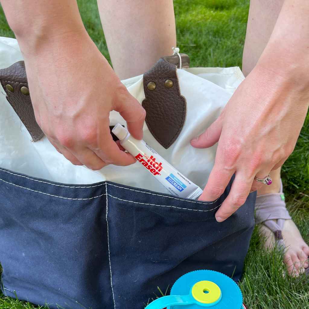 The Itch Eraser Sensitive Cream pulling out of blue and white tote bag