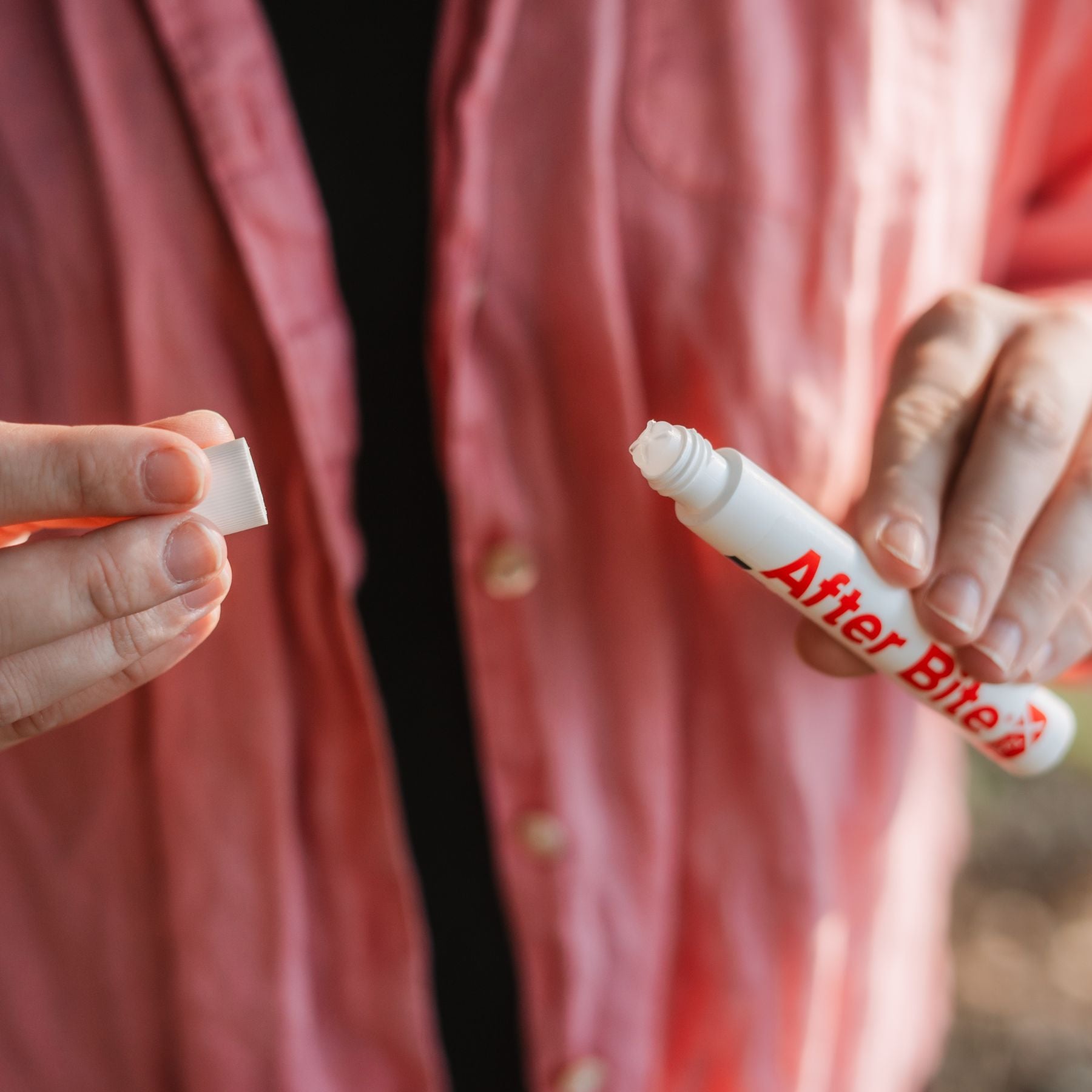 Woman removing cap from After Bite X-Tech