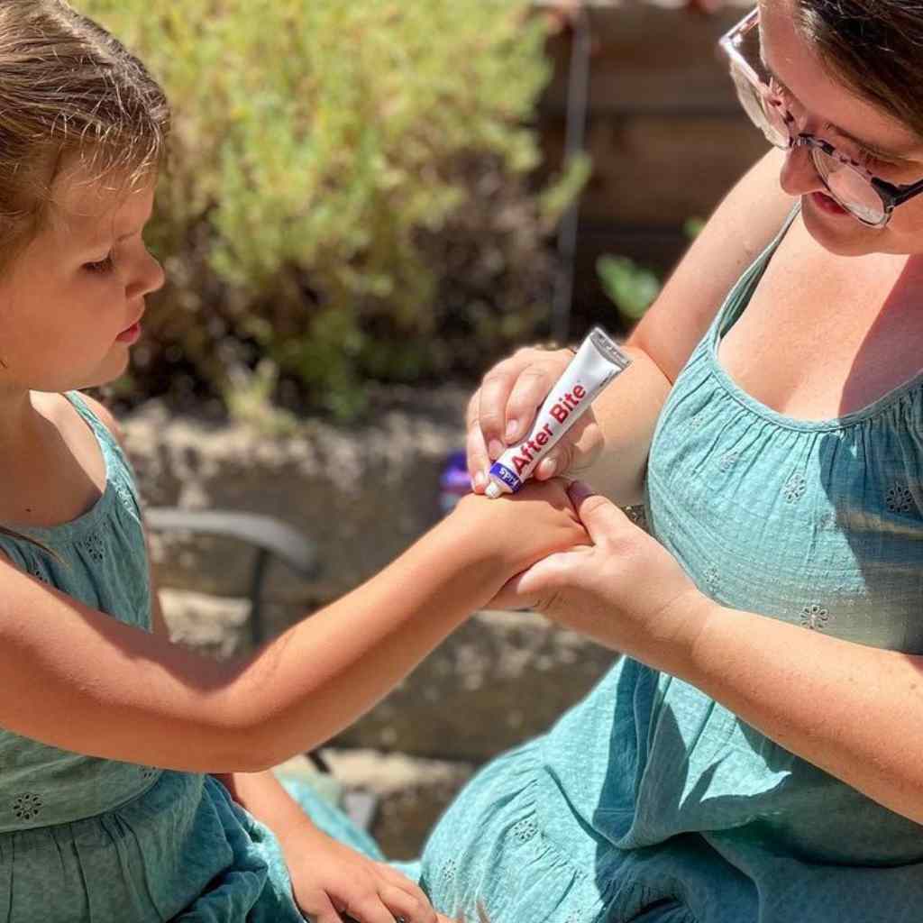 After Bite Kids mother and daughter in matching green dresses, mother applying to child's wrist