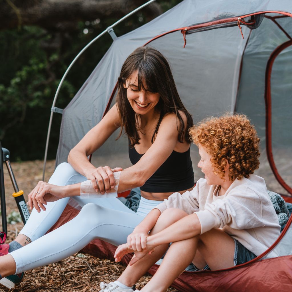 Woman using After Ivy wipe in front of a tent