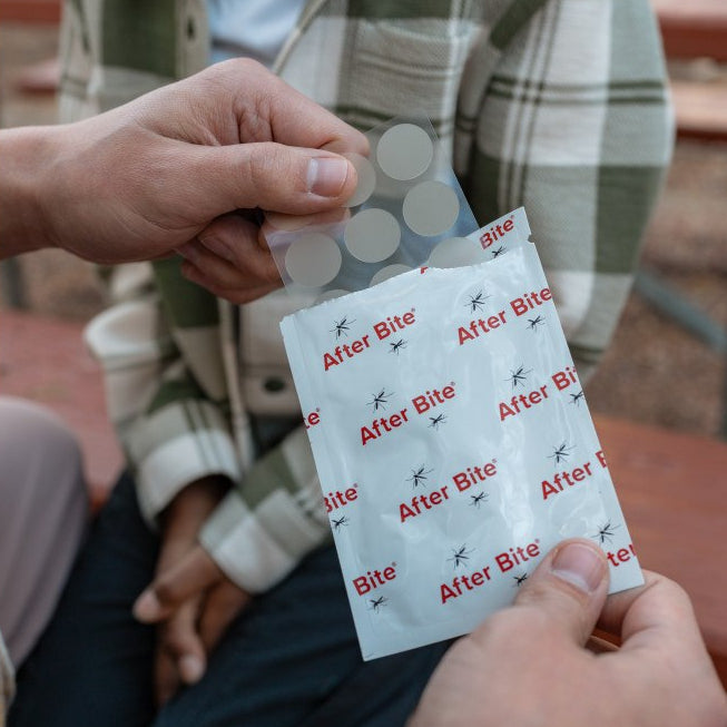 Adult pulling bug bite bandage sheet out of packaging